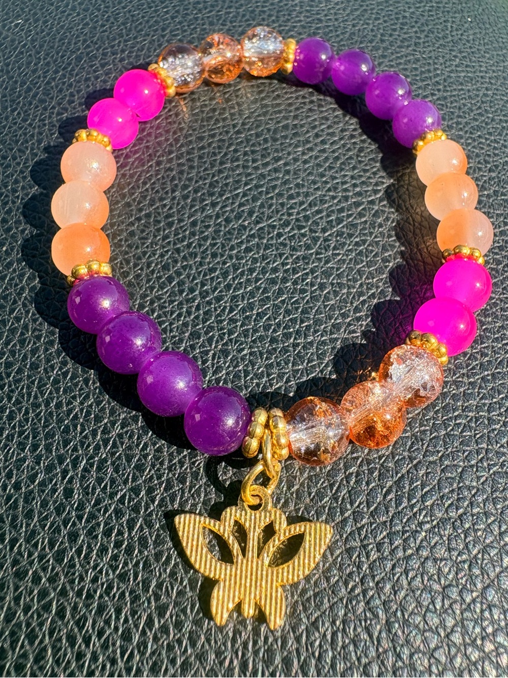 Purple,orange,pink glass beaded bracelet with gold accent an butterfly charm
